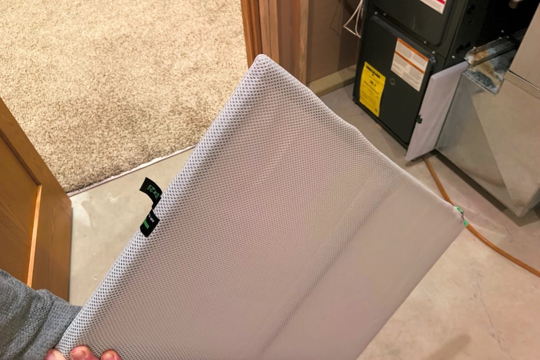 Pleated HVAC air filter being installed in a home furnace return
