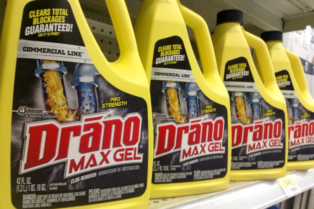 Row of drain cleaner bottles on a store shelf