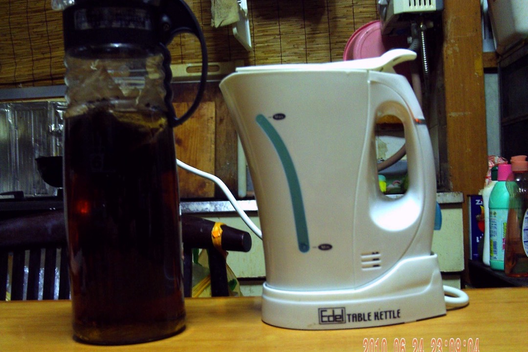 Electric kettle on a kitchen counter with steam rising from spout