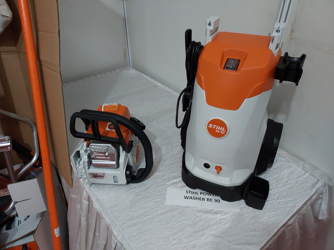 Electric pressure washer standing upright on a driveway