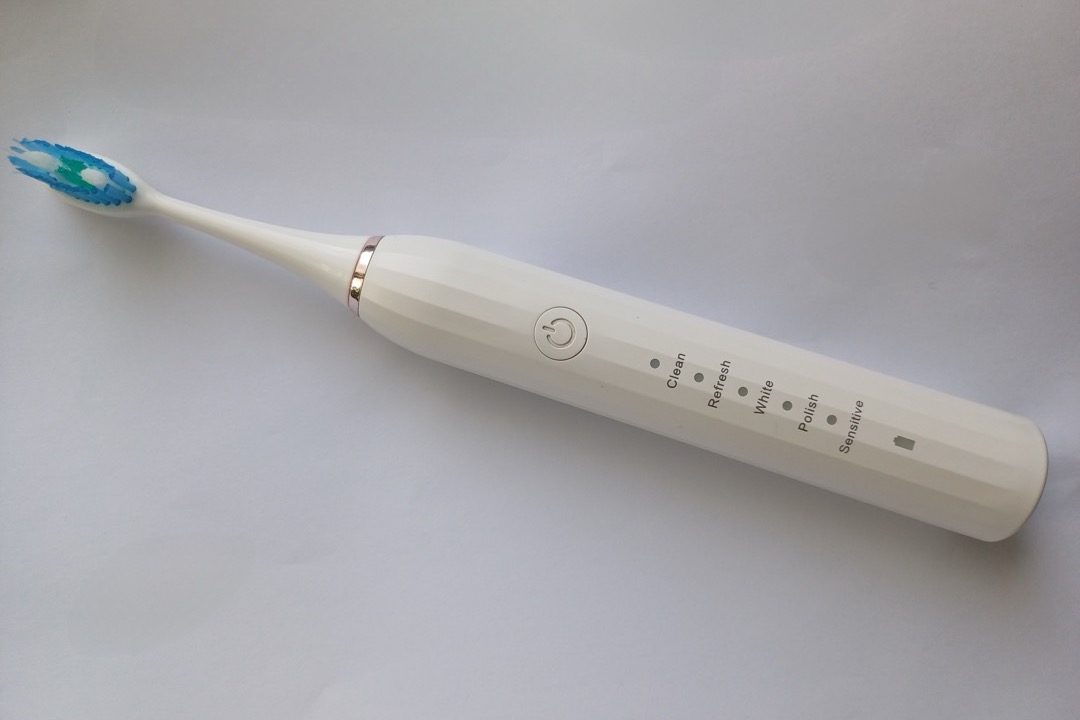 Electric toothbrush standing upright on a bathroom counter