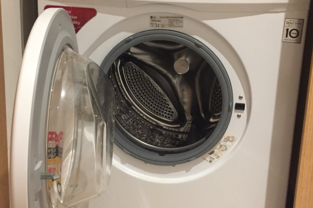 Front load washing machine with porthole door in a laundry room