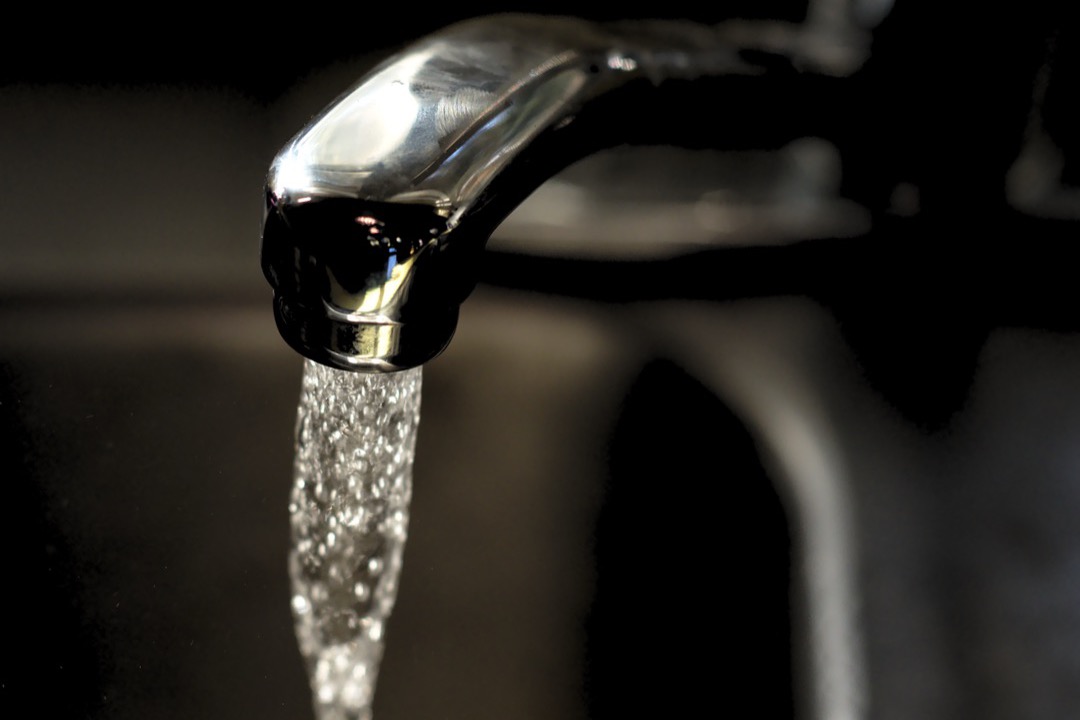 Modern pull-down kitchen faucet installed over a stainless steel sink