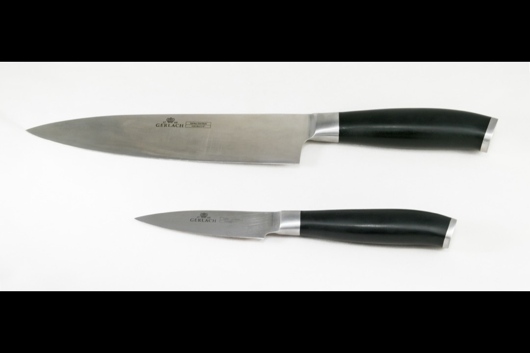 Kitchen knife set displayed on a wooden cutting board with chef's knife in foreground