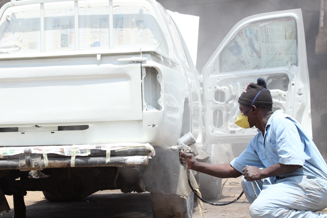 Airless paint sprayer with hose and spray gun on a job site