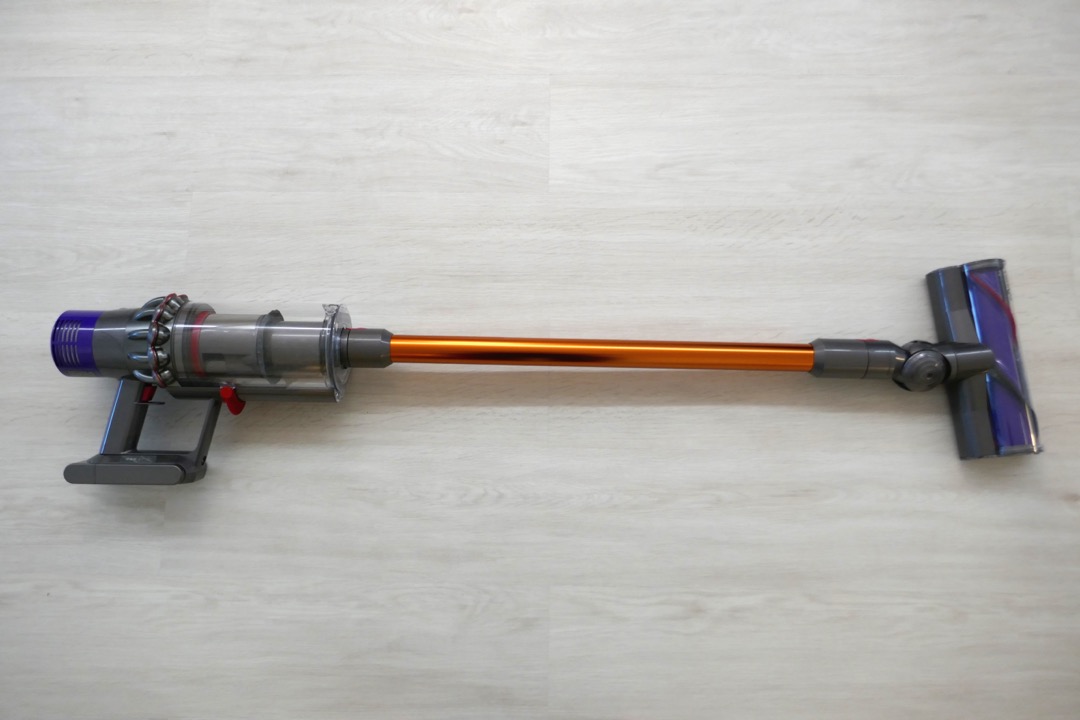 Cordless stick vacuum on hardwood floor in a modern home